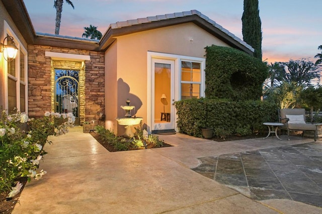 exterior entry at dusk with a patio area