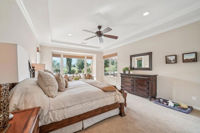 bedroom with crown molding, light colored carpet, a tray ceiling, and ceiling fan