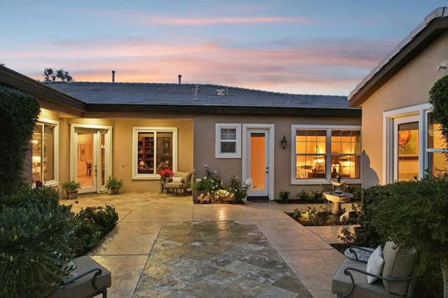 back house at dusk with a patio