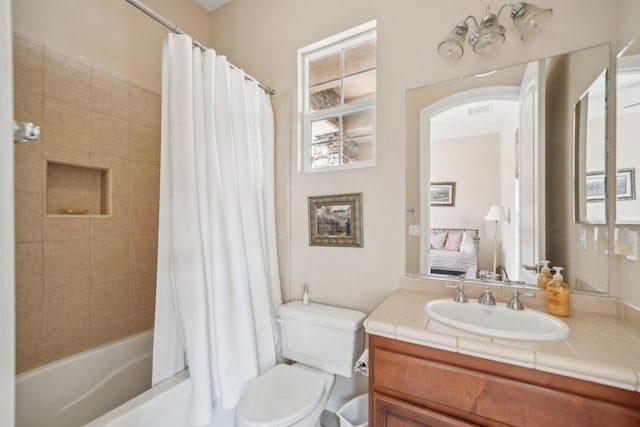 full bathroom with vanity, shower / tub combo with curtain, and toilet