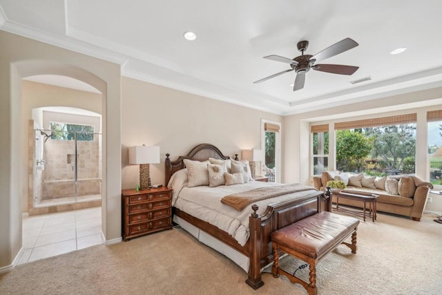 carpeted bedroom featuring crown molding, ceiling fan, connected bathroom, and a tray ceiling