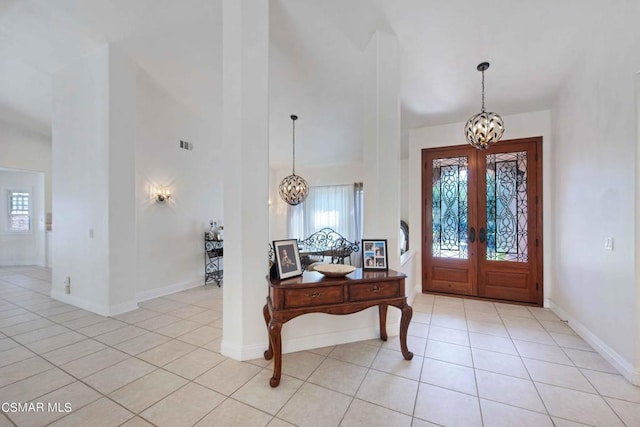 entrance foyer with plenty of natural light, light tile patterned floors, and a chandelier