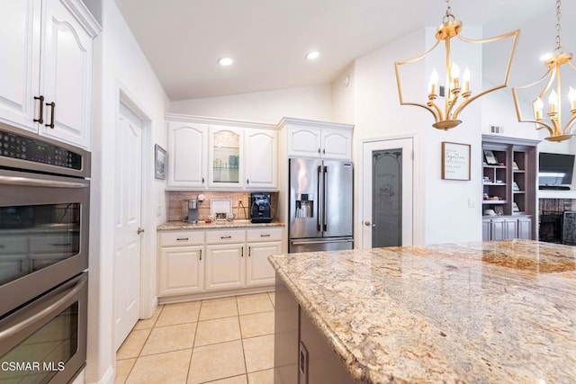 kitchen featuring stainless steel appliances, hanging light fixtures, white cabinets, and light stone counters