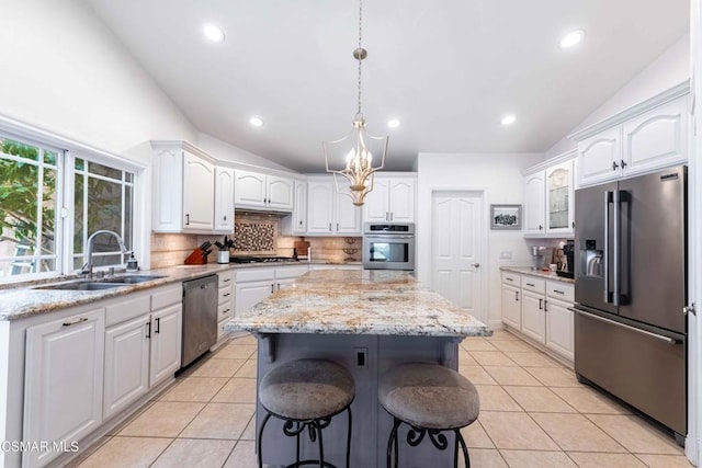 kitchen featuring stainless steel appliances, a center island, sink, and white cabinets