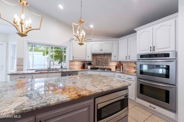 kitchen with appliances with stainless steel finishes, sink, white cabinets, and an inviting chandelier