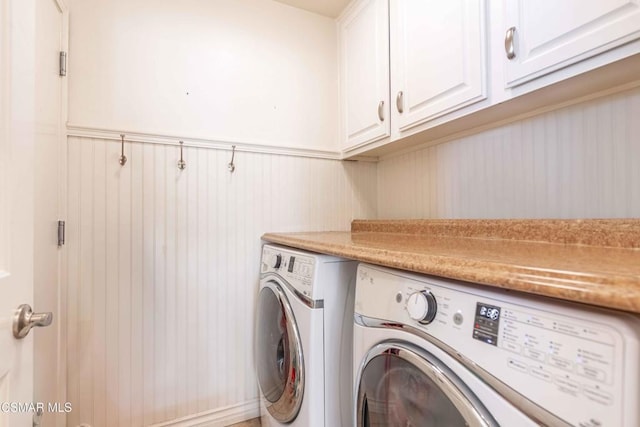 laundry area with washing machine and dryer and cabinets