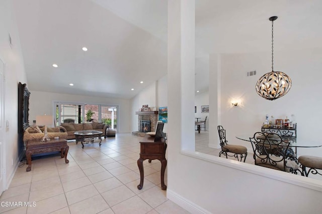 interior space featuring light tile patterned floors, a notable chandelier, and high vaulted ceiling