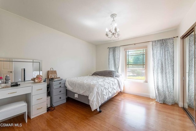 bedroom with a chandelier and light hardwood / wood-style floors