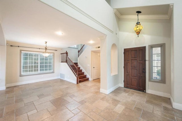 entrance foyer featuring crown molding and a wealth of natural light