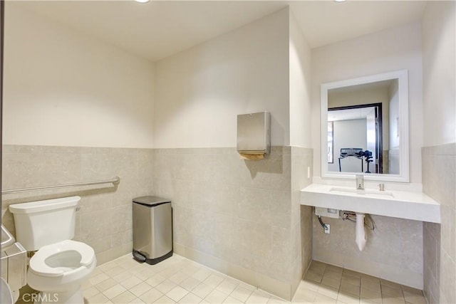 bathroom featuring tile walls, tile patterned flooring, and toilet