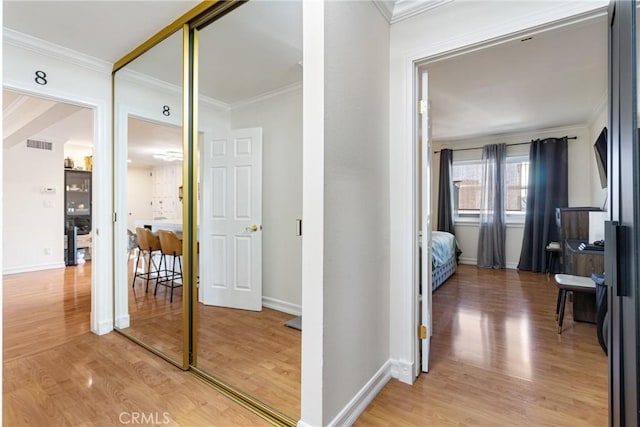 hall with hardwood / wood-style floors and ornamental molding