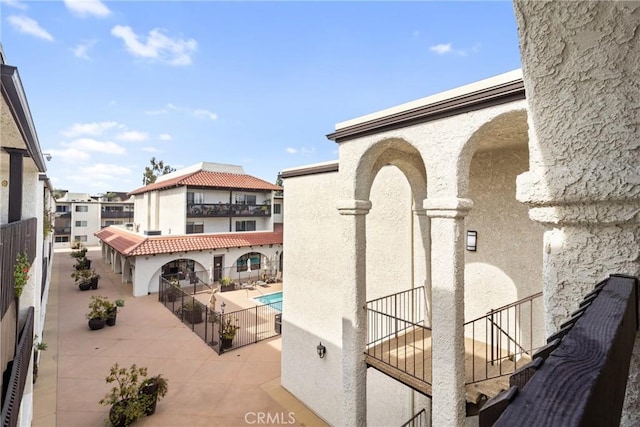 exterior space with a community pool, a patio area, and a balcony