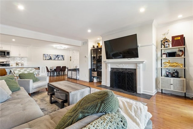 living room featuring ornamental molding and light wood-type flooring