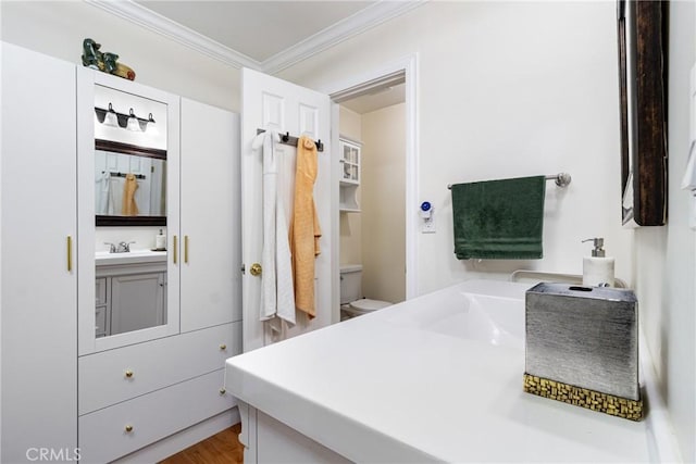 bathroom with vanity, hardwood / wood-style flooring, ornamental molding, and toilet