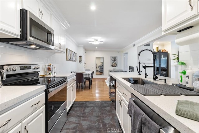 kitchen featuring sink, crown molding, backsplash, stainless steel appliances, and white cabinets