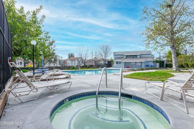 view of swimming pool featuring a community hot tub and a patio area