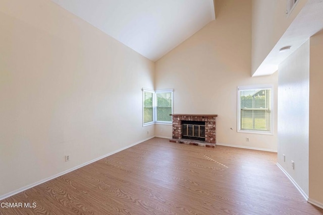 unfurnished living room featuring a fireplace, light hardwood / wood-style floors, and a wealth of natural light