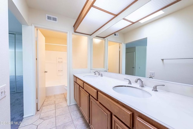 bathroom featuring vanity, a skylight, tile patterned floors, and toilet