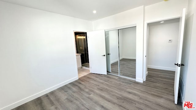 unfurnished bedroom featuring light hardwood / wood-style floors and a closet