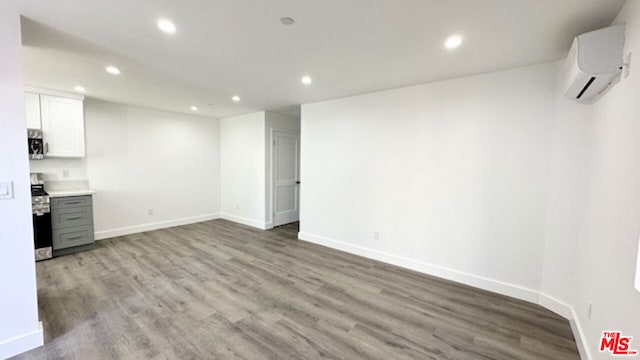 interior space featuring wood-type flooring and a wall unit AC