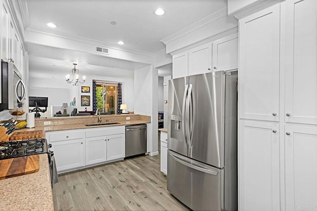 kitchen with stainless steel appliances, ornamental molding, sink, and white cabinets