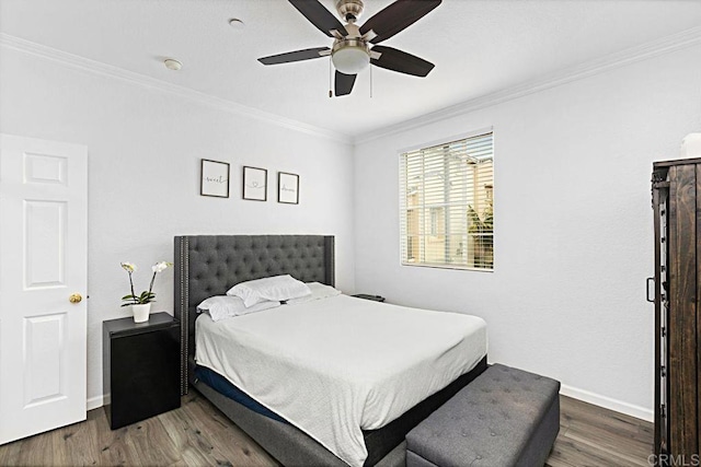 bedroom featuring crown molding, dark wood-type flooring, and ceiling fan