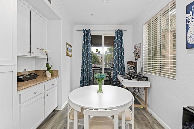 dining area with hardwood / wood-style flooring and ornamental molding