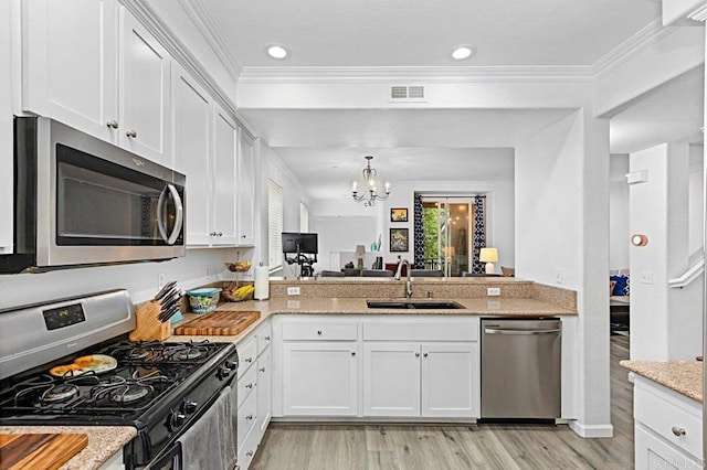 kitchen with light stone counters, sink, white cabinets, and appliances with stainless steel finishes