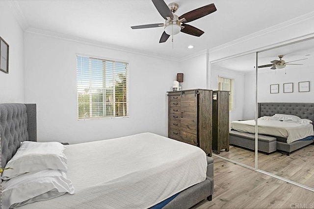 bedroom featuring wood-type flooring, ceiling fan, crown molding, and a closet