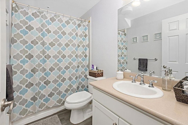 bathroom with vanity, wood-type flooring, and toilet