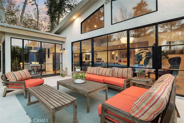 patio terrace at dusk featuring outdoor lounge area