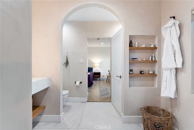 bathroom with built in features and toilet