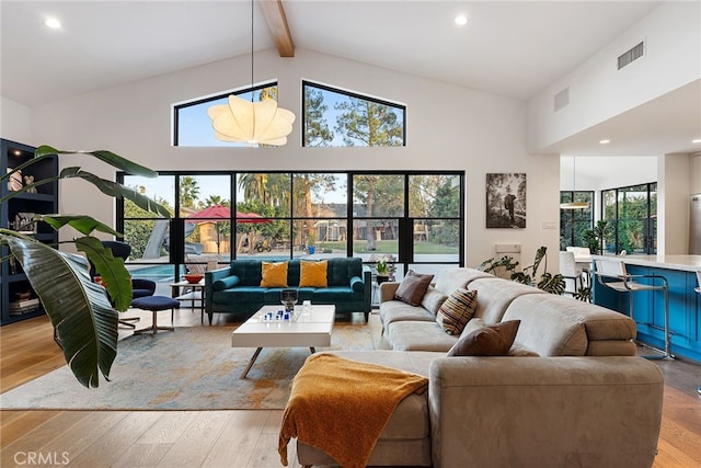 living room featuring beamed ceiling, high vaulted ceiling, and light hardwood / wood-style floors