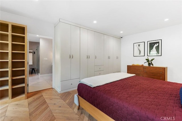 bedroom featuring light parquet flooring and a closet