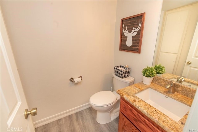 bathroom with hardwood / wood-style flooring, vanity, and toilet