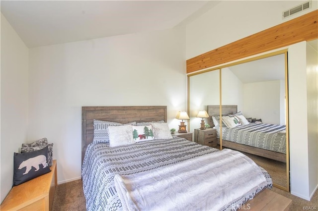 carpeted bedroom with vaulted ceiling and a closet