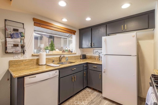 kitchen with white appliances, sink, and light wood-type flooring