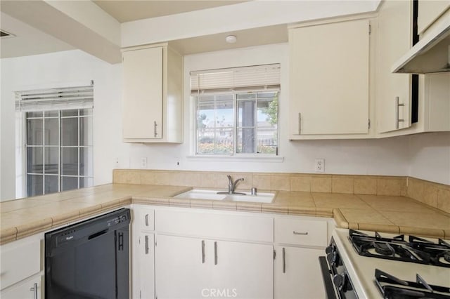 kitchen with tile countertops, under cabinet range hood, a sink, range with gas stovetop, and black dishwasher