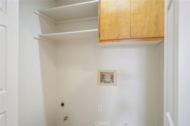 clothes washing area with washer hookup, hookup for a gas dryer, cabinet space, and electric dryer hookup