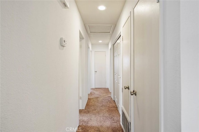 hall featuring recessed lighting, attic access, and light colored carpet