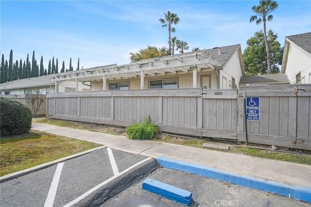 uncovered parking lot featuring a fenced front yard