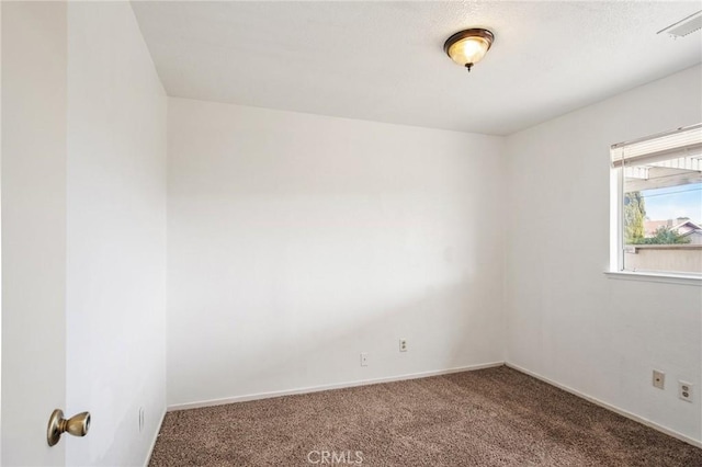 empty room featuring carpet, visible vents, and baseboards