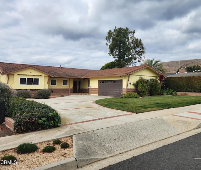 ranch-style house featuring a garage and a front yard