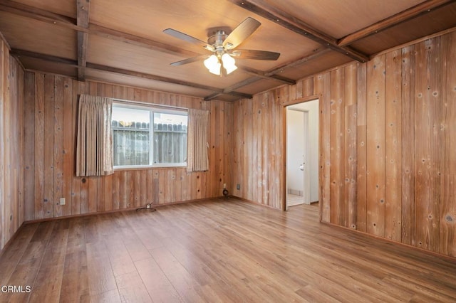 spare room featuring wooden walls, coffered ceiling, light hardwood / wood-style floors, and beam ceiling