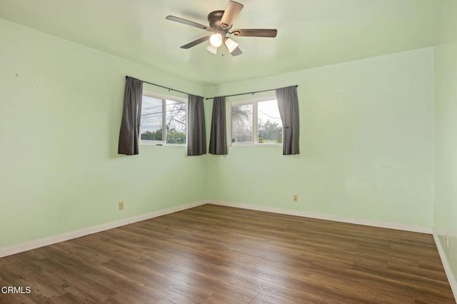 spare room with dark hardwood / wood-style floors and ceiling fan