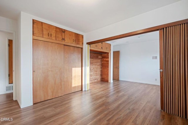 unfurnished bedroom featuring hardwood / wood-style floors and a closet