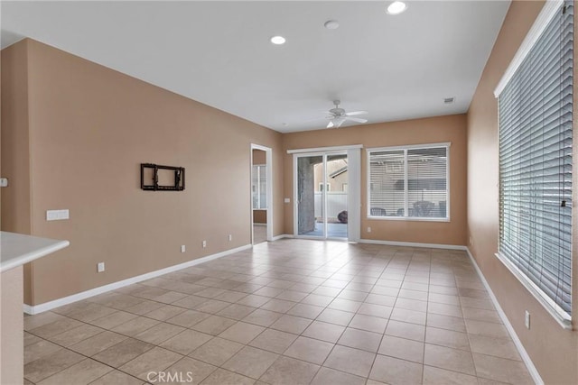 tiled empty room featuring ceiling fan and a healthy amount of sunlight