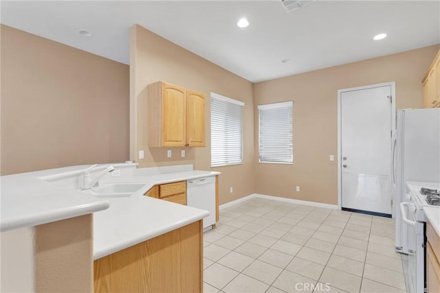 kitchen with sink, white appliances, light tile patterned floors, light brown cabinetry, and kitchen peninsula