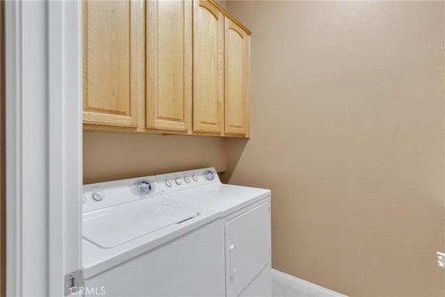 laundry area with cabinets and washing machine and clothes dryer