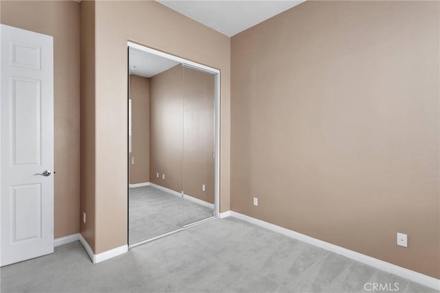 unfurnished bedroom featuring a closet and light carpet